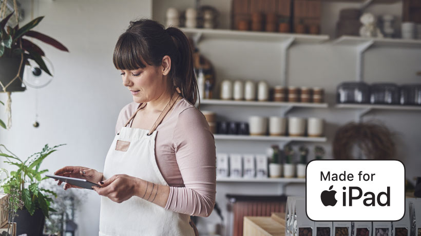 MFiのアイコンを重ねた、店内でiPadを使用する女性の写真